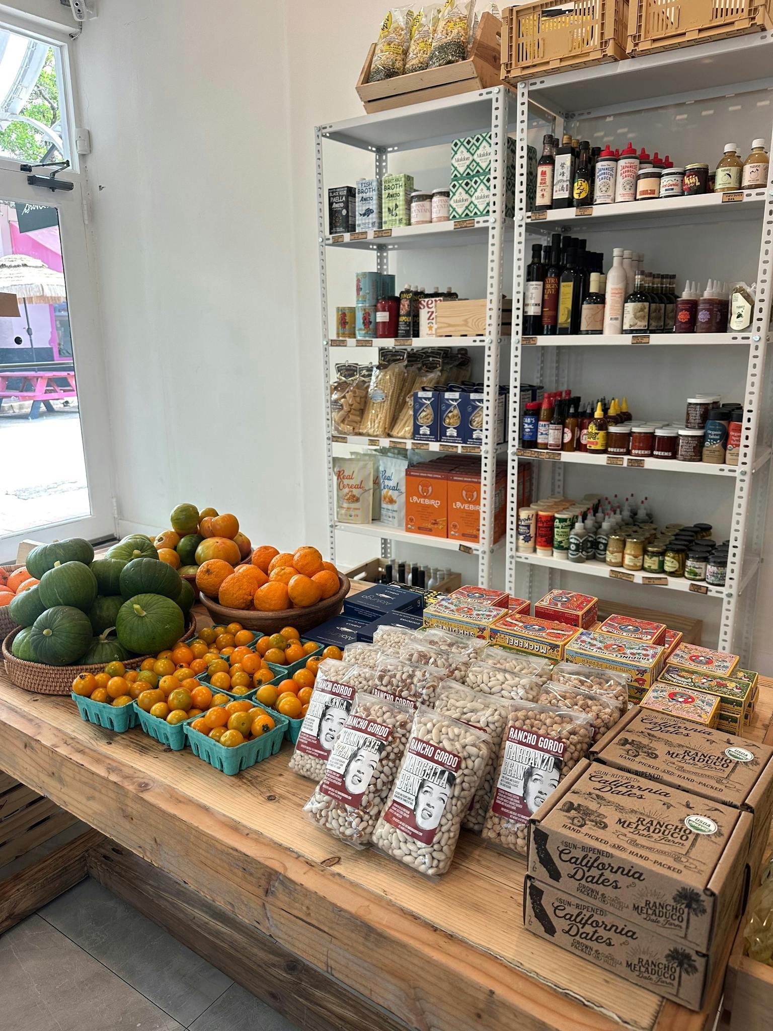 A variety of fresh fruits and organic products in a sunny grocery store setting.
