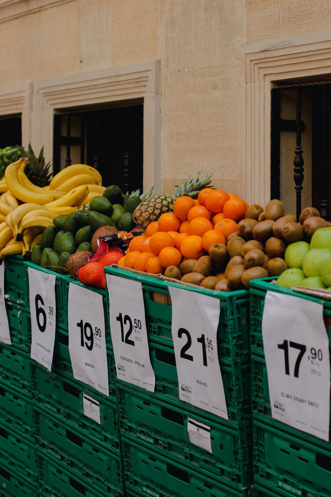 Fresh assortment of fruits including bananas, oranges, and avocados in a market setting.